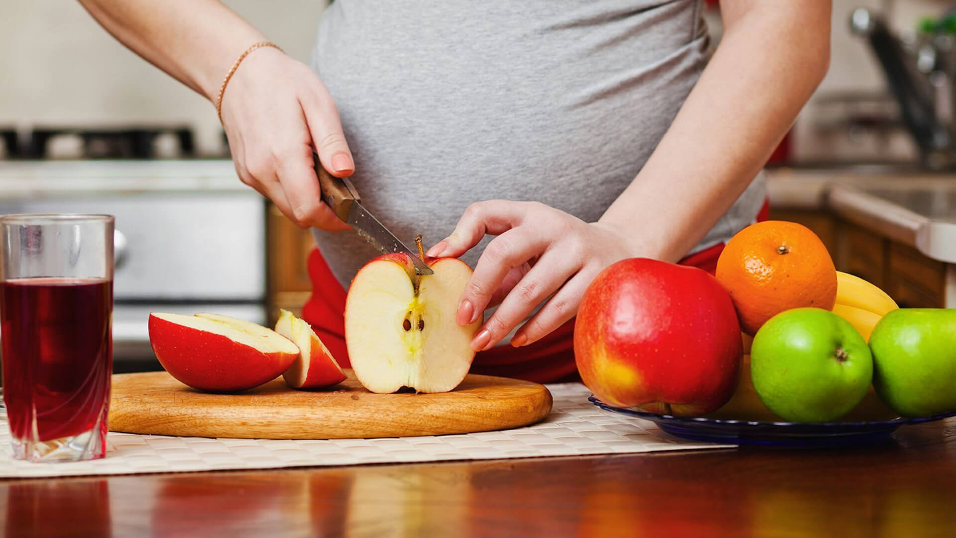 Pregnant woman cutting an apple
