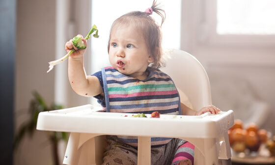 Toddler in high chair eating