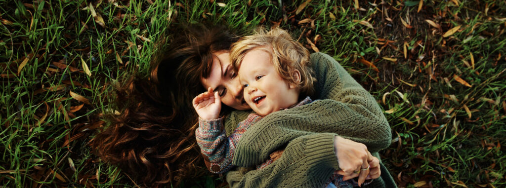 Parent with kid in the grass