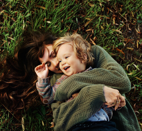 Parent with kid in the grass