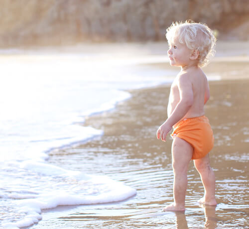 Baby with cloth nappies on the beach